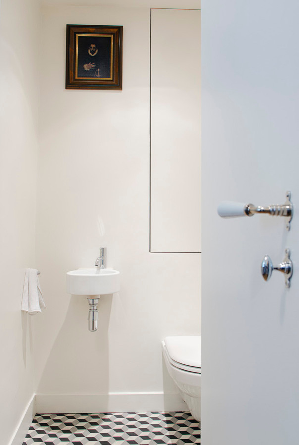 Kleine Klassische Gästetoilette mit Wandtoilette, beiger Wandfarbe, Terrakottaboden, Wandwaschbecken, buntem Boden und weißer Waschtischplatte in Paris
