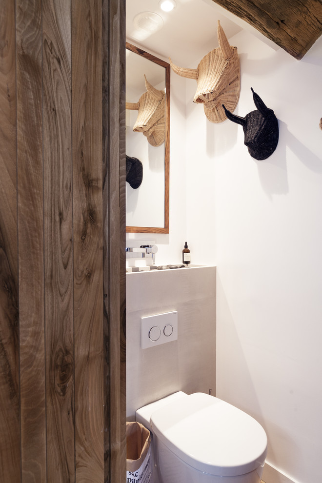 Idée de décoration pour un petit WC suspendu nordique avec un mur blanc.