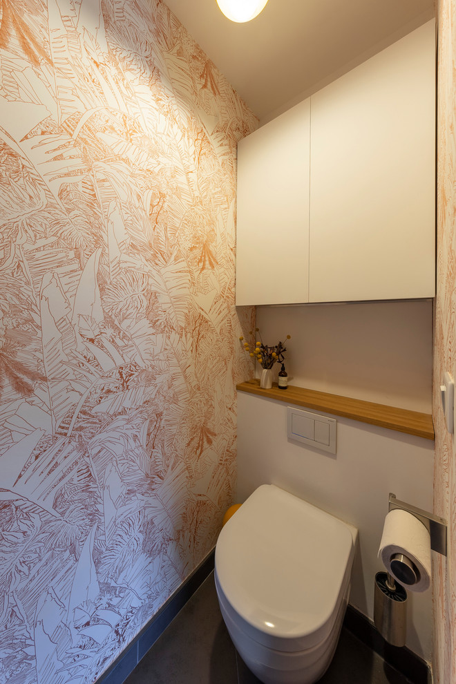 Aménagement d'un WC suspendu moderne de taille moyenne avec un placard à porte affleurante, des portes de placard blanches, un carrelage blanc, un mur blanc, un sol en carrelage de céramique, un plan de toilette en bois, un sol gris et un plan de toilette marron.