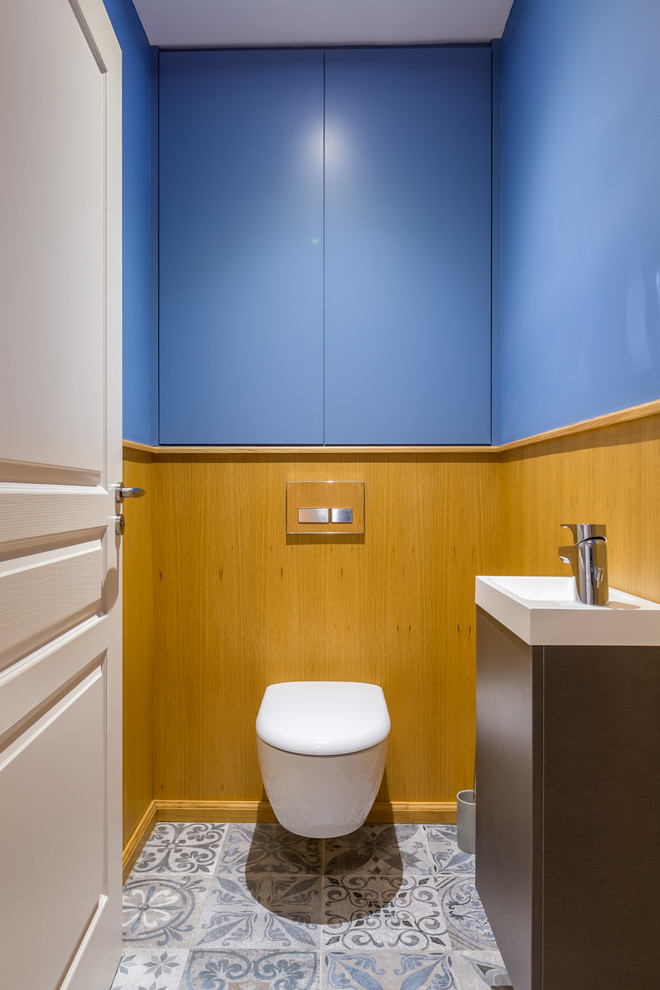 Idée de décoration pour un WC suspendu design de taille moyenne avec un mur bleu et un lavabo posé.