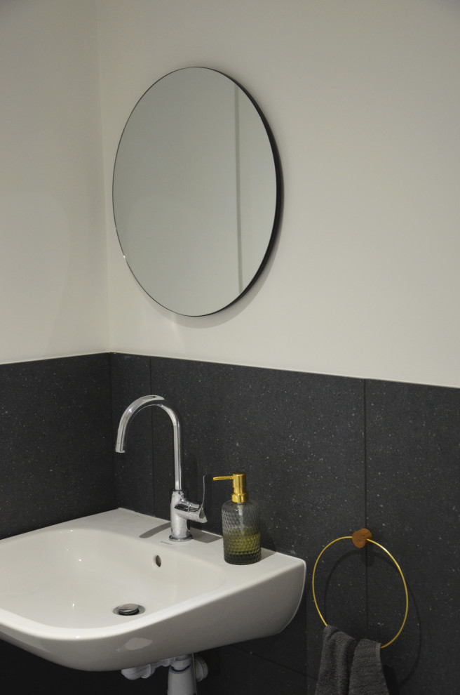 На фото: туалет среднего размера в современном стиле с унитазом-моноблоком, черно-белой плиткой, керамической плиткой, белыми стенами, полом из керамической плитки, подвесной раковиной и черным полом с