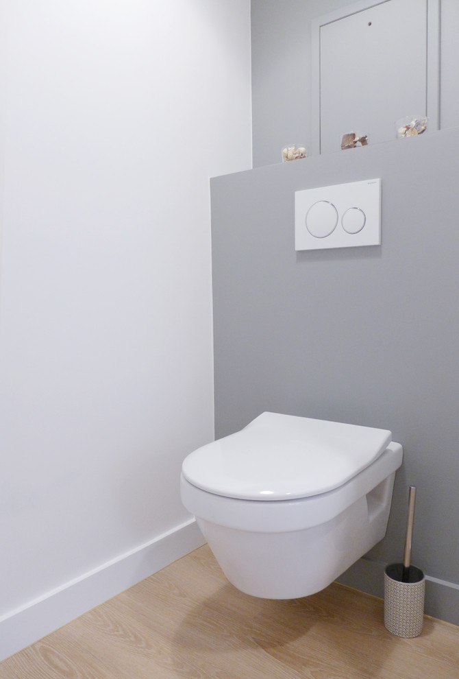 Идея дизайна: туалет среднего размера в современном стиле с инсталляцией, серыми стенами и светлым паркетным полом