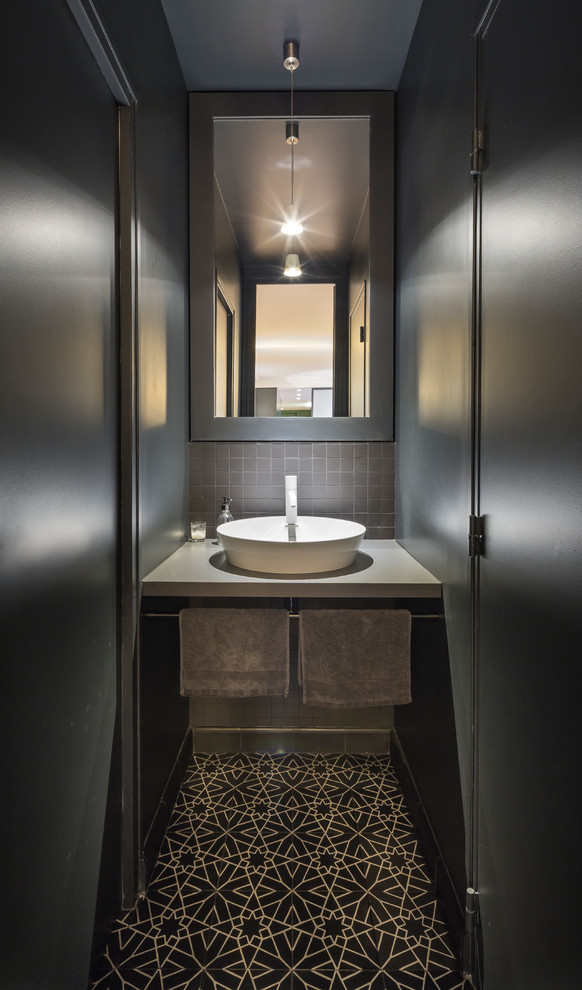 Свежая идея для дизайна: большой туалет в современном стиле с черной плиткой, керамической плиткой, черными стенами, полом из цементной плитки, накладной раковиной, столешницей из ламината и черным полом - отличное фото интерьера