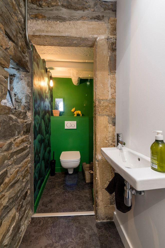 На фото: туалет в современном стиле с инсталляцией, зелеными стенами, полом из винила, подвесной раковиной и серым полом с