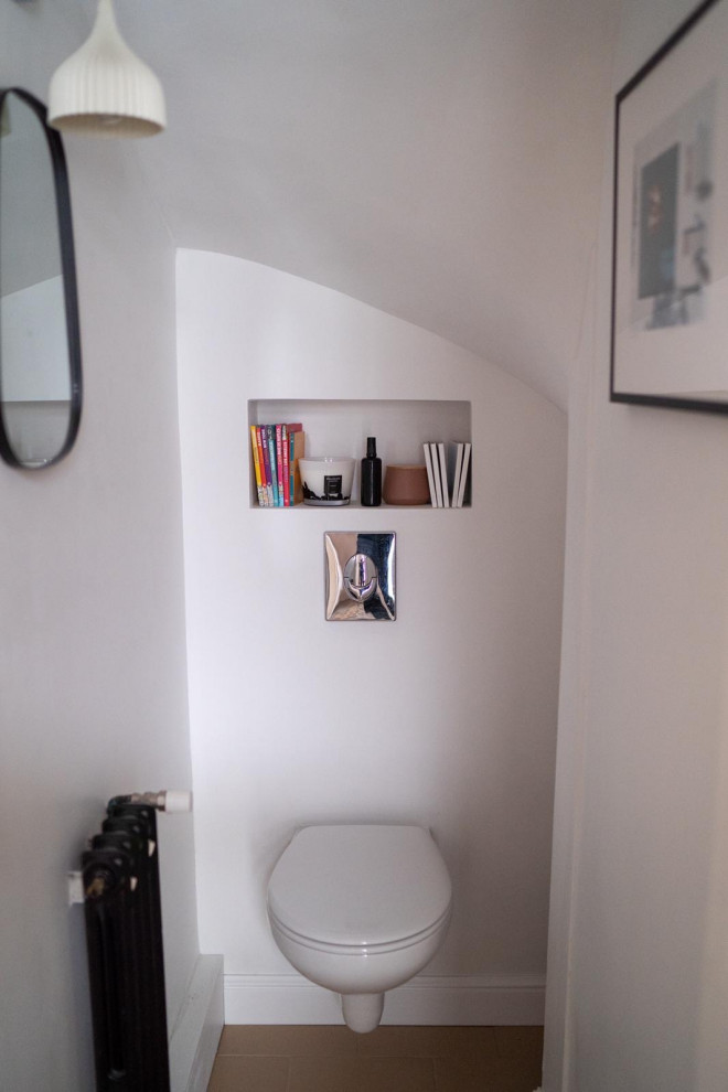Idee per un piccolo bagno di servizio minimal con WC sospeso, pareti bianche, pavimento con piastrelle in ceramica e pavimento arancione