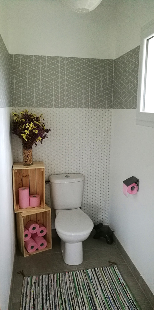 Réalisation d'un petit WC et toilettes nordique avec un placard sans porte, WC séparés, un mur gris et un sol gris.