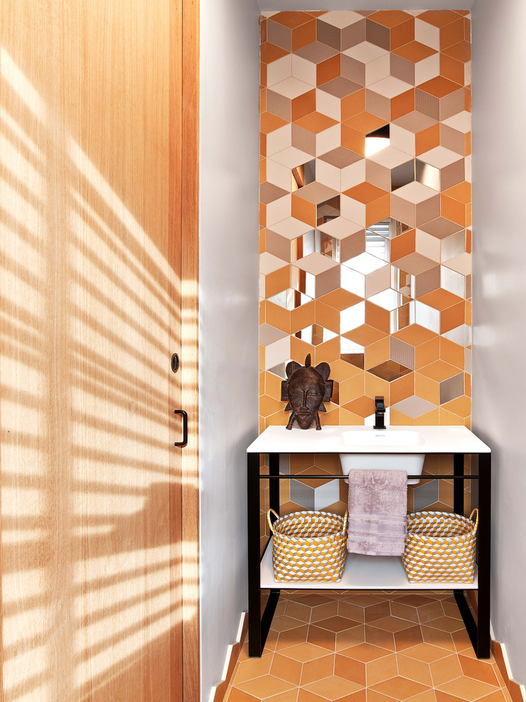 Источник вдохновения для домашнего уюта: туалет в стиле фьюжн с оранжевой плиткой, желтыми стенами, оранжевым полом, врезной раковиной и белой столешницей