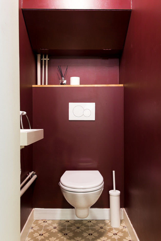 Immagine di un piccolo bagno di servizio minimal con WC sospeso, pareti rosse, pavimento in cementine e lavabo sospeso