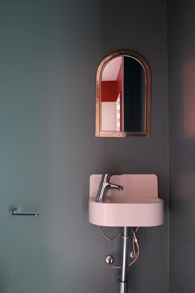 Cette photo montre un petit WC suspendu tendance avec un placard à porte plane, des portes de placard grises, un carrelage blanc, du carrelage en marbre, un mur vert, un sol en linoléum, un lavabo suspendu et un sol gris.