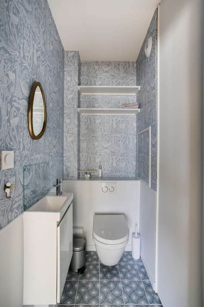 ルアーブルにあるお手頃価格の小さなコンテンポラリースタイルのおしゃれなトイレ・洗面所 (壁掛け式トイレ、青い壁、セラミックタイルの床、壁付け型シンク、青い床、白い洗面カウンター) の写真