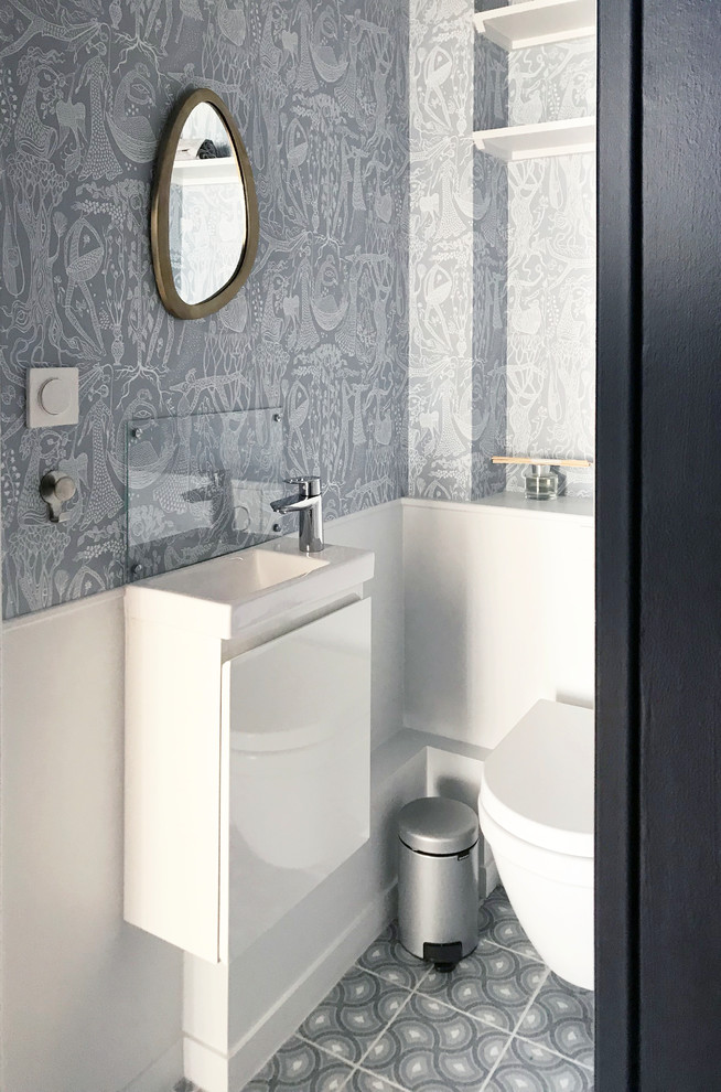 Imagen de aseo contemporáneo pequeño con sanitario de pared, paredes azules, suelo de baldosas de cerámica, lavabo suspendido, suelo azul y encimeras blancas