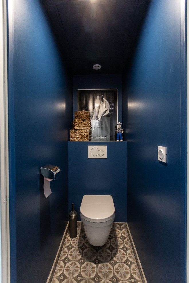 Inspiration for a small modern cloakroom in Lyon with a wall mounted toilet, blue walls and cement flooring.