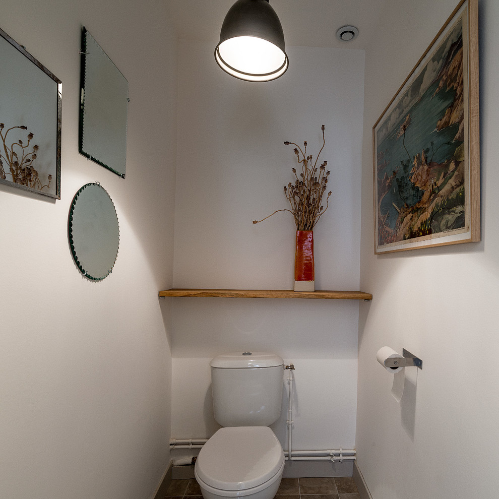 Inspiration för små lantliga toaletter, med en toalettstol med hel cisternkåpa, vita väggar, cementgolv och beiget golv