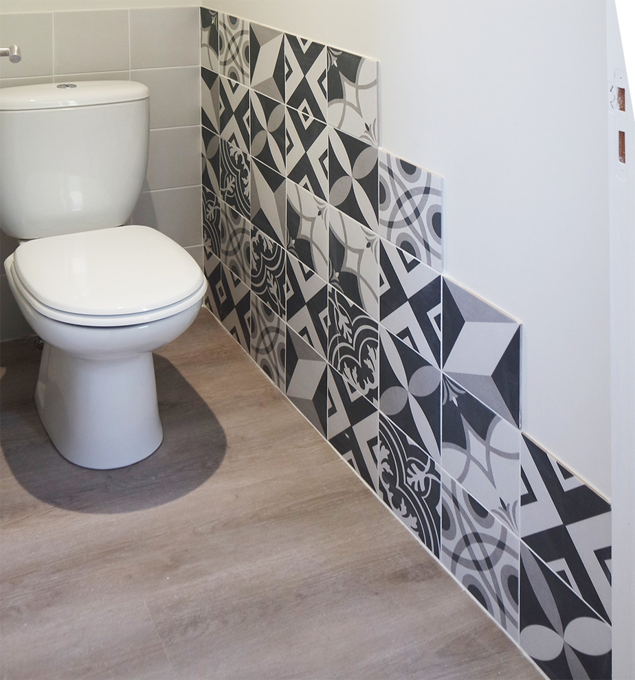 Bild på ett skandinaviskt toalett, med en toalettstol med hel cisternkåpa, ljust trägolv och beiget golv