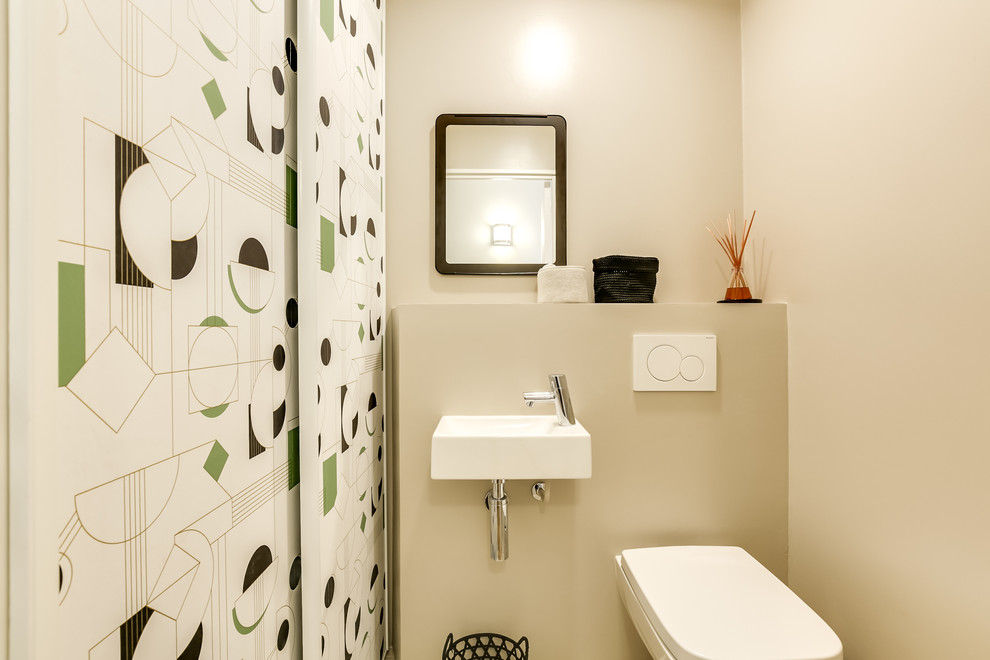 Стильный дизайн: туалет среднего размера в современном стиле с фасадами с декоративным кантом, зелеными фасадами, инсталляцией, бежевыми стенами, полом из керамической плитки, подвесной раковиной и бежевым полом - последний тренд