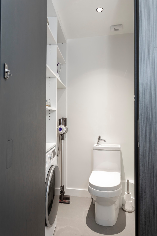 Exempel på ett litet modernt toalett, med vita skåp, en toalettstol med hel cisternkåpa, vita väggar och ett integrerad handfat