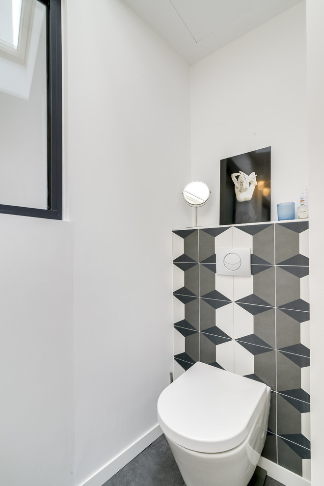 Powder room - mid-sized contemporary brown tile and ceramic tile vinyl floor and gray floor powder room idea in Paris with a wall-mount toilet, white walls, an undermount sink and tile countertops