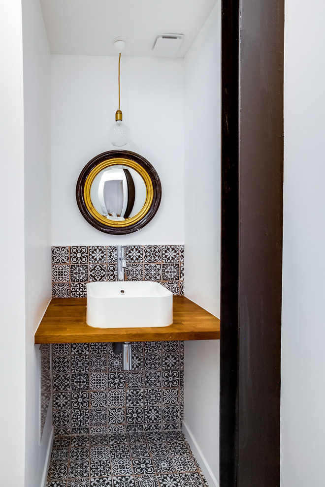 Kleine Moderne Gästetoilette mit Wandtoilette, farbigen Fliesen, Zementfliesen, weißer Wandfarbe, Zementfliesen für Boden, Waschtischkonsole und buntem Boden in Paris