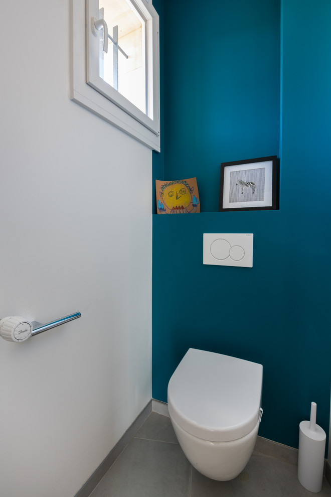 Источник вдохновения для домашнего уюта: маленький туалет в стиле неоклассика (современная классика) с фасадами с декоративным кантом, инсталляцией, белой плиткой, синими стенами, полом из керамической плитки, подвесной раковиной и серым полом для на участке и в саду