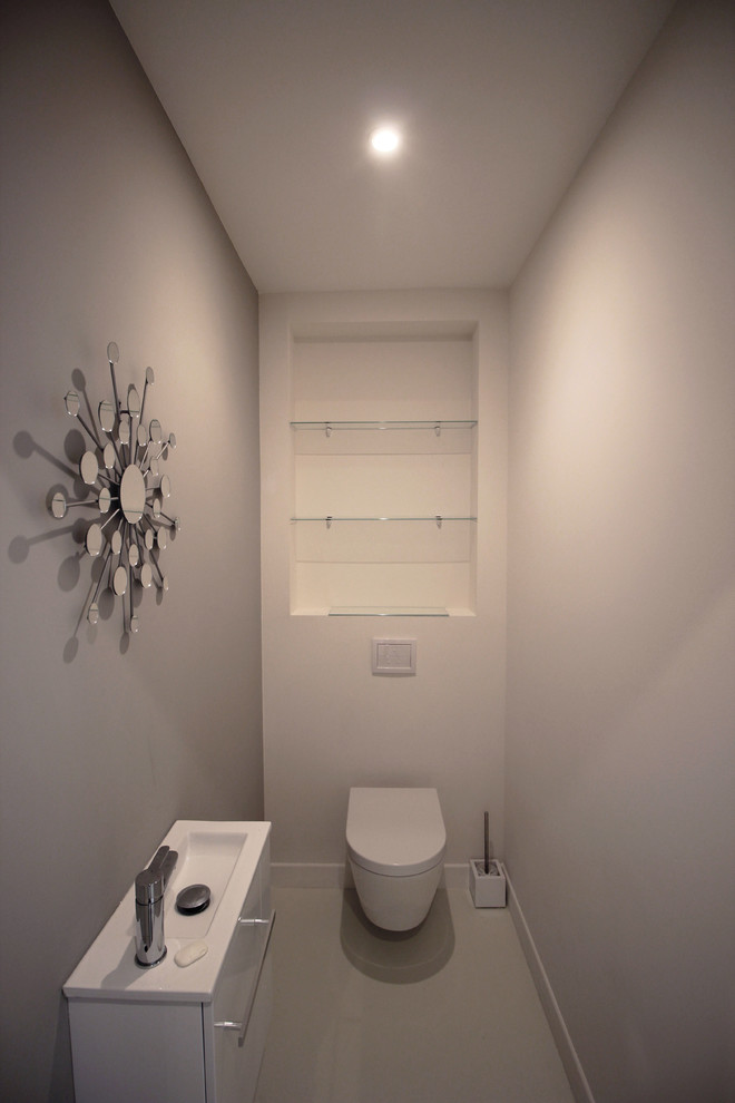 Inspiration pour un petit WC suspendu design avec un mur gris et un sol beige.