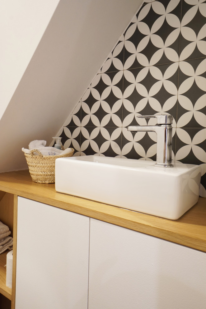 Inspiration for a small contemporary cloakroom in Paris with flat-panel cabinets, white cabinets, a wall mounted toilet, black and white tiles, white walls, a vessel sink, wooden worktops, beige worktops and a floating vanity unit.
