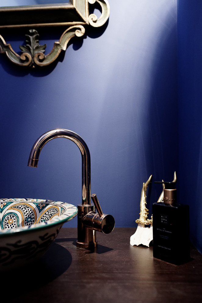 Kleine Landhausstil Gästetoilette mit Schrankfronten im Shaker-Stil, braunen Schränken, Wandtoilette, blauen Fliesen, Zementfliesen, blauer Wandfarbe, Bambusparkett, Einbauwaschbecken, Waschtisch aus Holz, braunem Boden und brauner Waschtischplatte in Sonstige