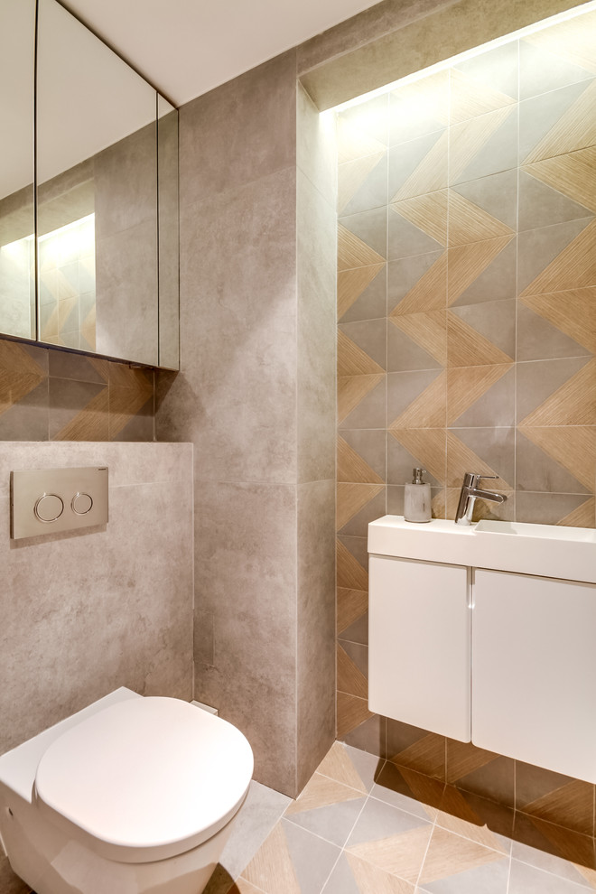 На фото: туалет в современном стиле с плоскими фасадами, белыми фасадами, инсталляцией, монолитной раковиной, серыми стенами, полом из керамической плитки и бежевым полом