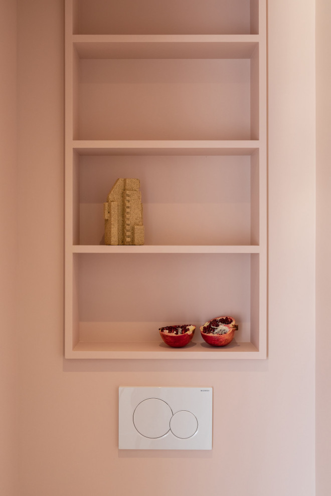 Ejemplo de aseo flotante moderno pequeño con armarios abiertos, sanitario de pared, paredes rosas, suelo de baldosas de cerámica, suelo blanco y encimeras naranjas