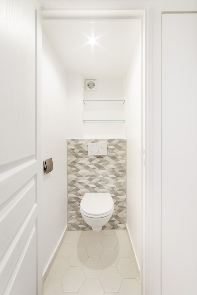 This is an example of a small contemporary cloakroom in Paris with a wall mounted toilet, multi-coloured tiles, porcelain tiles, porcelain flooring and beige floors.