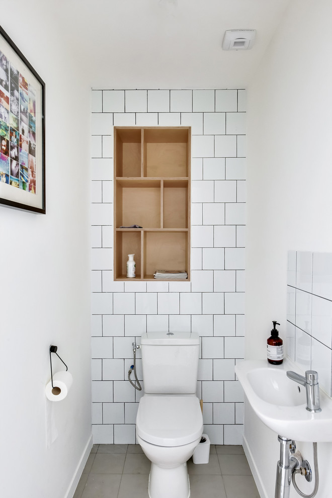 Contemporary cloakroom in Paris with open cabinets, a two-piece toilet, white tiles, porcelain tiles, white walls, a console sink and grey floors.