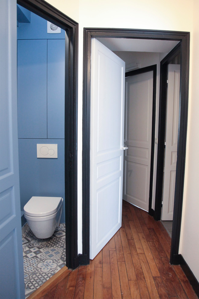 Пример оригинального дизайна: маленький туалет в современном стиле с фасадами с декоративным кантом, синими фасадами, инсталляцией, разноцветной плиткой, керамической плиткой, синими стенами, полом из керамической плитки, подвесной раковиной и разноцветным полом для на участке и в саду