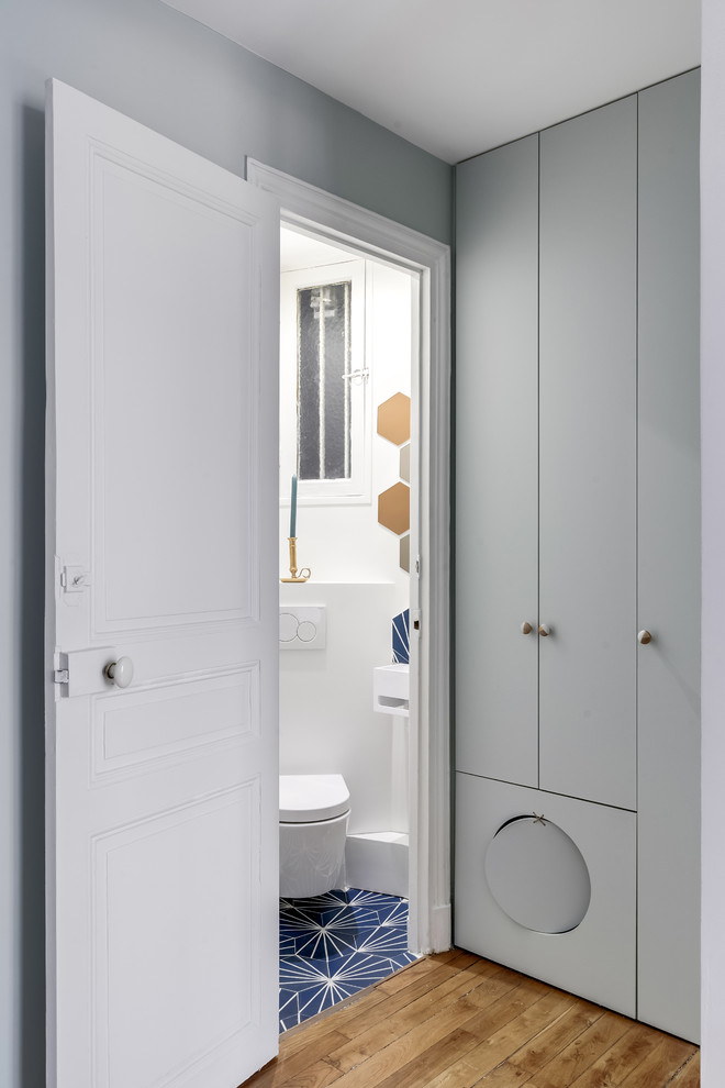 Idées déco pour un WC suspendu contemporain avec un carrelage bleu, des carreaux de béton, un mur blanc, carreaux de ciment au sol et un lavabo suspendu.