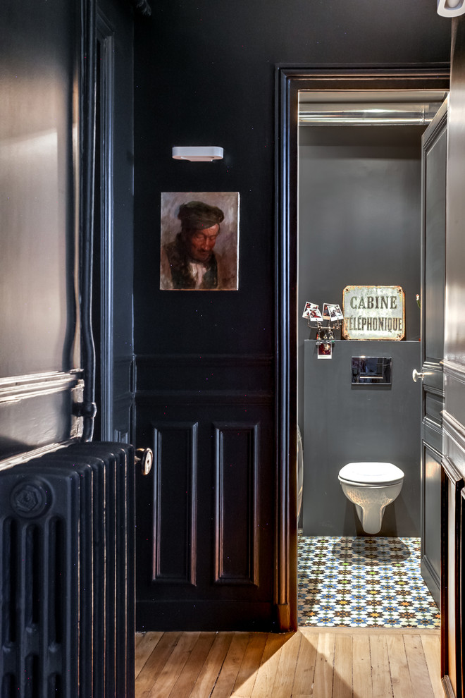 На фото: туалет в стиле неоклассика (современная классика) с инсталляцией, разноцветной плиткой, черными стенами и полом из цементной плитки с