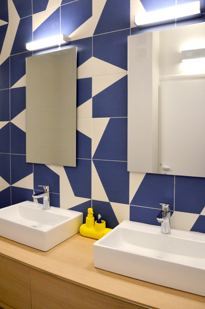 Réalisation d'un WC et toilettes design de taille moyenne avec un carrelage bleu, un lavabo posé et un plan de toilette en bois.