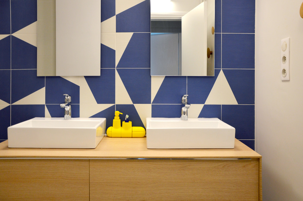 Exemple d'un WC et toilettes tendance de taille moyenne avec un carrelage bleu, un lavabo posé et un plan de toilette en bois.