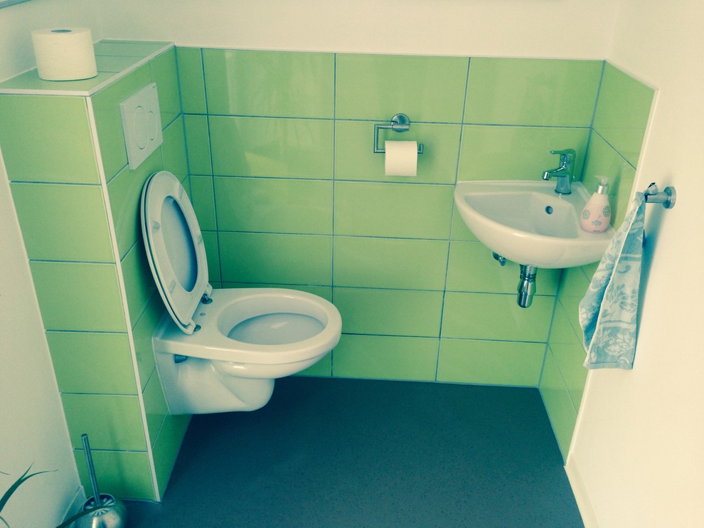 Photo of a small traditional cloakroom in Strasbourg with a wall mounted toilet and green tiles.