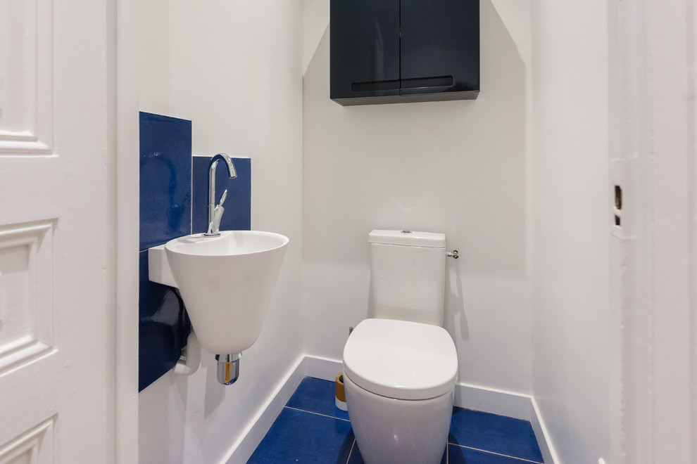 Inspiration pour un WC et toilettes design de taille moyenne avec WC à poser, un carrelage bleu, un mur blanc, un sol en carrelage de céramique et un sol bleu.