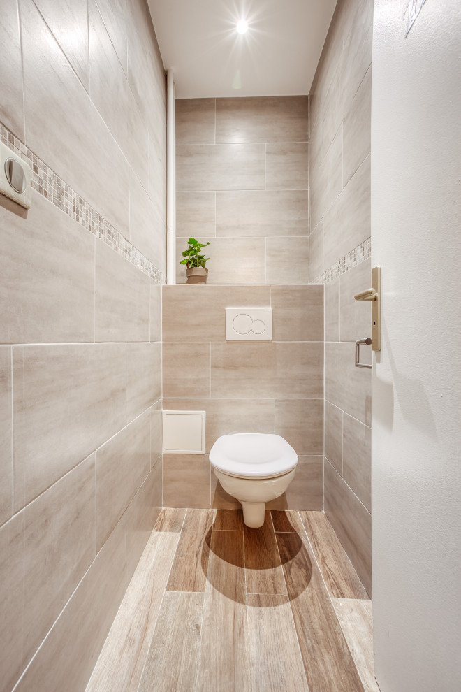 Design ideas for a large contemporary cloakroom in Paris with a wall mounted toilet and tiled worktops.