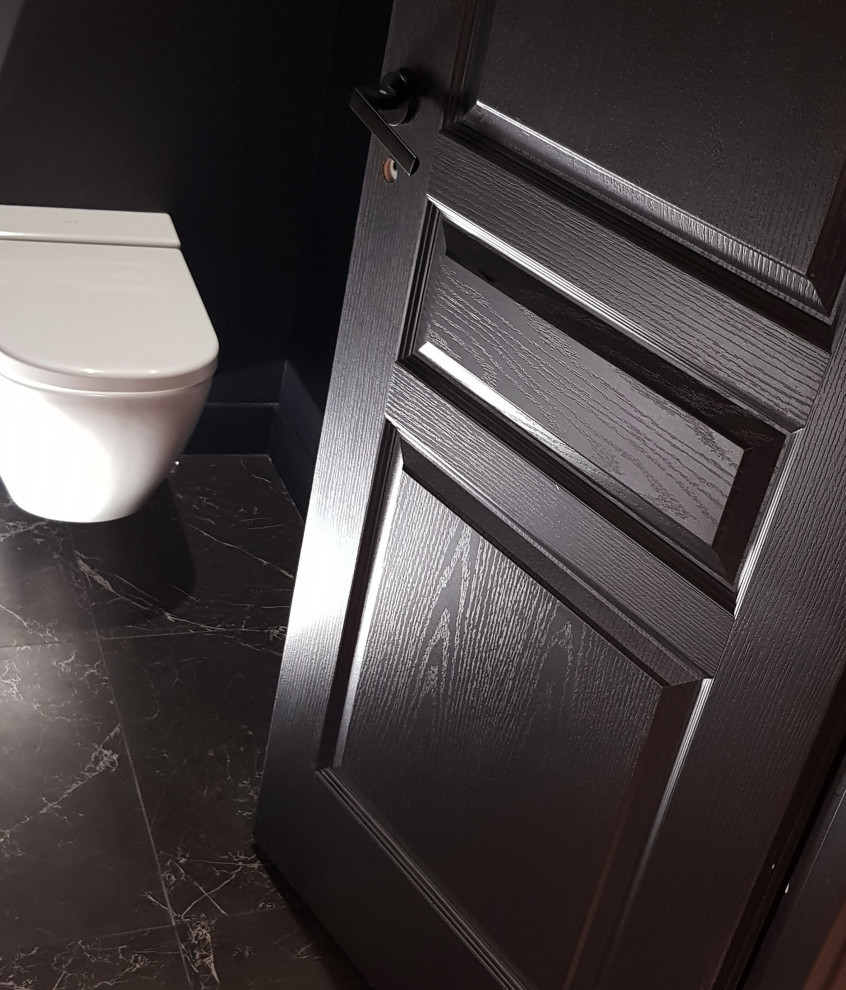 Idee per un piccolo bagno di servizio minimal con WC sospeso, pareti nere, pavimento in marmo e pavimento nero