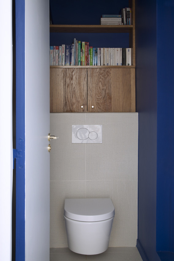 Mittelgroße Moderne Gästetoilette mit Wandtoilette, beigen Fliesen, blauer Wandfarbe, grauem Boden und weißer Waschtischplatte in Paris