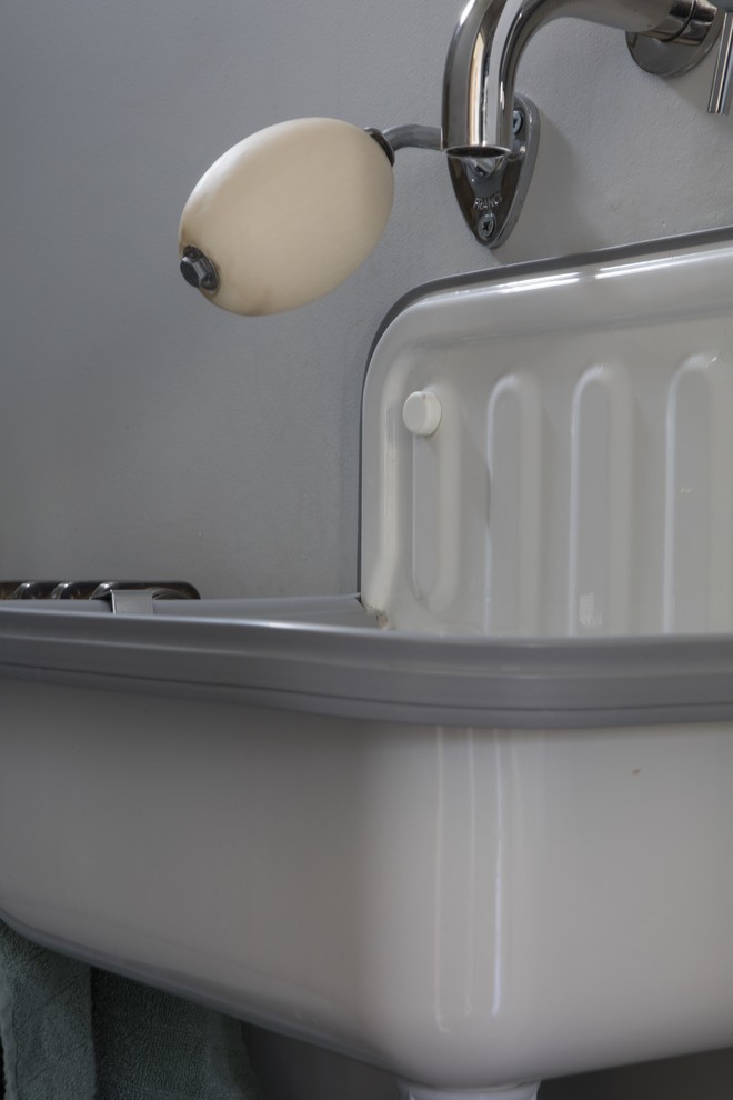 Aménagement d'un WC suspendu éclectique de taille moyenne avec un mur blanc, sol en béton ciré, un lavabo suspendu et un sol gris.