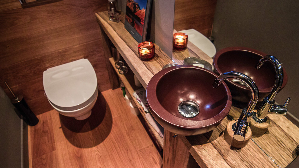 Exemple d'un petit WC suspendu tendance avec un mur violet, un sol en carrelage de céramique, un lavabo posé, un plan de toilette en bois, un sol beige et un plan de toilette beige.