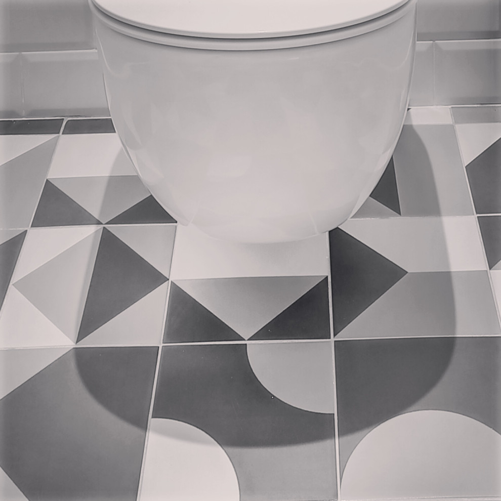 Cette photo montre un petit WC suspendu tendance avec un carrelage blanc, un carrelage métro, un mur blanc, carreaux de ciment au sol, un lavabo suspendu et un sol gris.