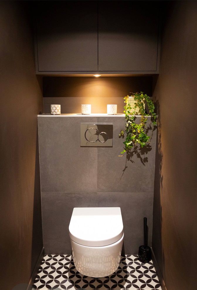 Foto di un piccolo bagno di servizio moderno con WC sospeso, piastrelle marroni, piastrelle in ceramica, pareti marroni, pavimento con piastrelle in ceramica, pavimento bianco, ante a filo e ante marroni
