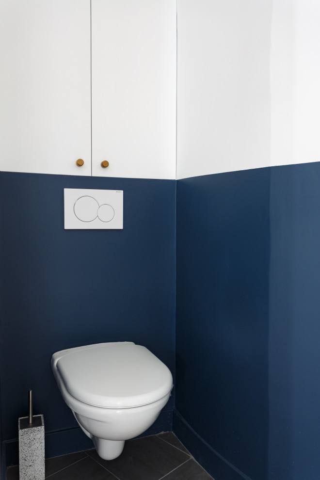 Inspiration for a small scandinavian cloakroom in Other with beaded cabinets, white cabinets, a wall mounted toilet, blue tiles, blue walls, ceramic flooring, grey floors and white worktops.