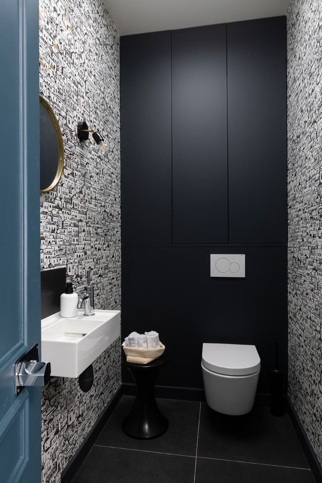 На фото: туалет среднего размера в современном стиле с инсталляцией, полом из керамогранита, подвесной раковиной, черным полом и разноцветными стенами