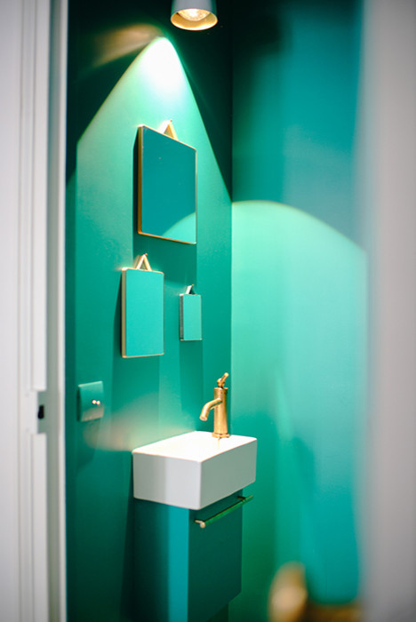 Moderne Gästetoilette mit Wandtoilette, grüner Wandfarbe und integriertem Waschbecken in Paris