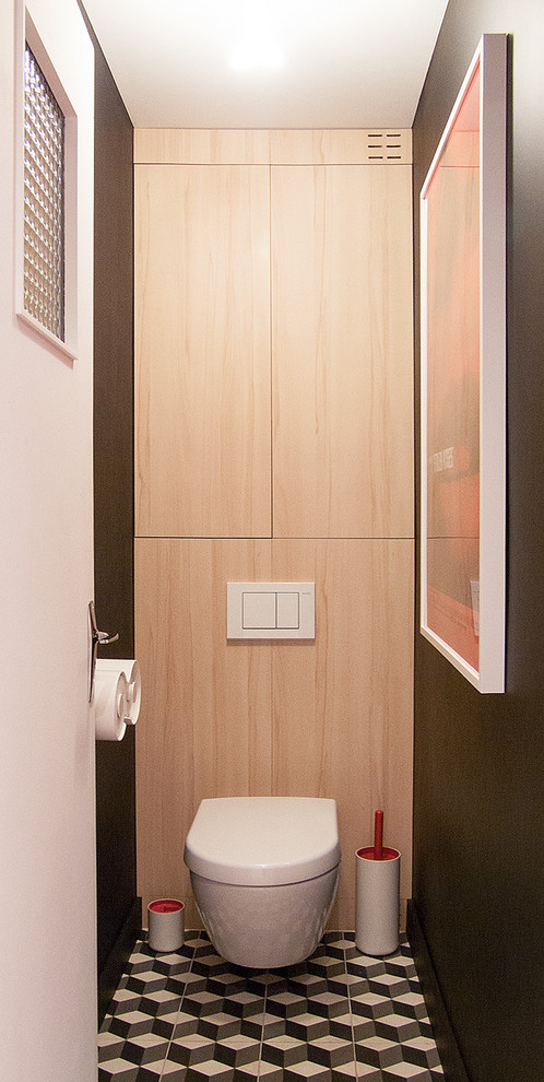 Idées déco pour un WC suspendu moderne en bois clair avec un placard à porte plane, un mur noir, carreaux de ciment au sol et un sol noir.