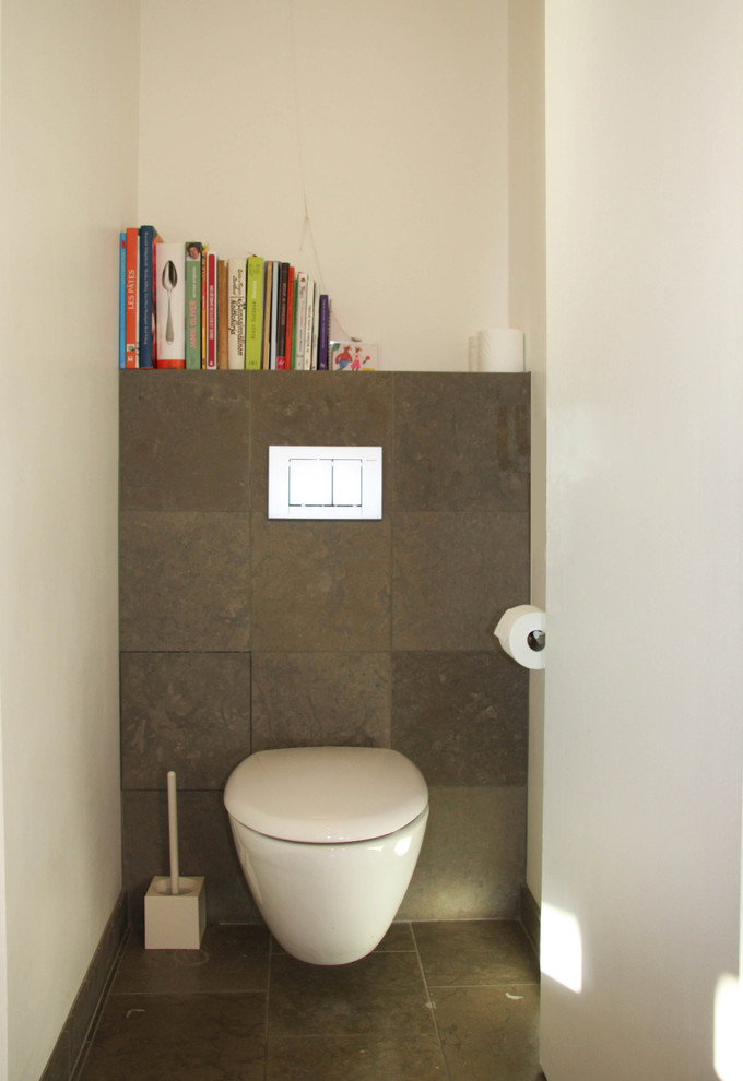 Inspiration pour un petit WC suspendu design avec un carrelage gris, un carrelage de pierre, un mur gris, un sol en calcaire et un sol gris.