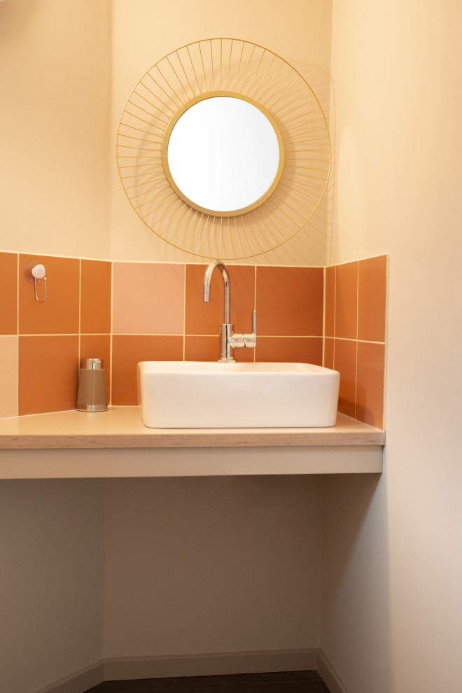 Idées déco pour un WC suspendu contemporain de taille moyenne avec un carrelage rose, un mur beige, un sol en vinyl, un lavabo posé, un plan de toilette en stratifié et un plan de toilette beige.